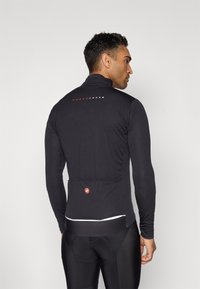 Maillot de cyclisme noir à manches longues avec col montant, doté d'une poche arrière, d'un accent blanc à l'ourlet et de "ROSSOCORSA" imprimé en rouge au dos.