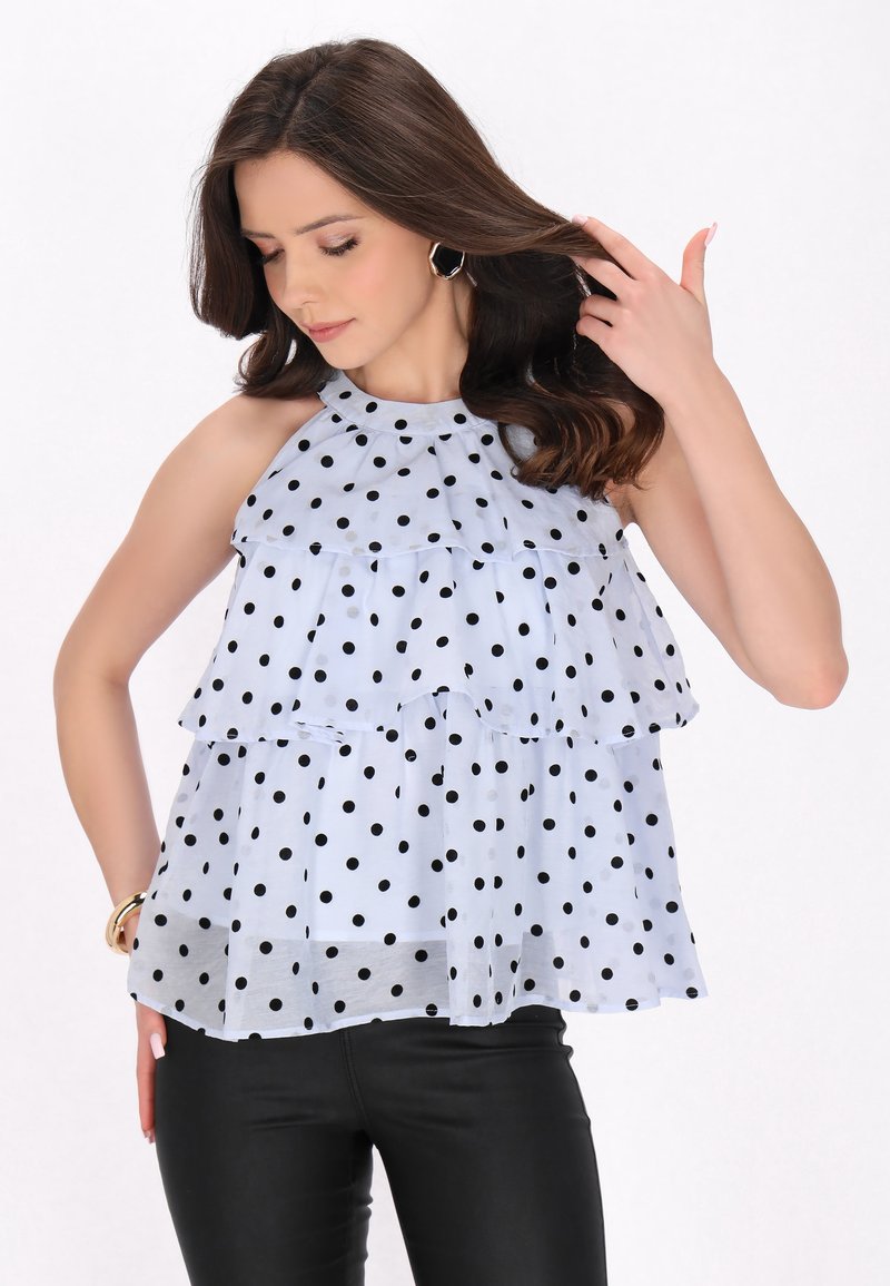 Top a spalle scoperte blu chiaro a strati con pois neri, con un collo all'halterneck. Tessuto testurizzato con una vestibilità fluida e morbida.