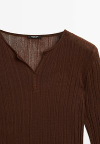 Hnědý žebrovaný top s dlouhými rukávy a výstřihem henley. Vyrobený z lehk�ého materiálu s jemnou texturou a přiléhavým střihem.