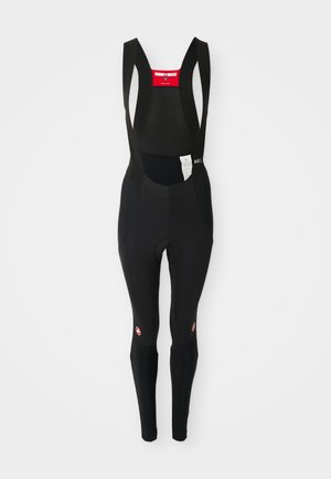 Des collants de cyclisme noirs avec des bretelles ajustables, un haut en mesh, un siège rembourré et un logo près de la cheville, conçus pour le confort et la performance.