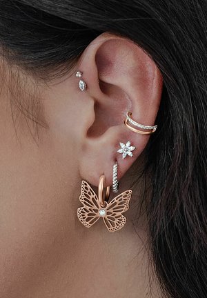 Ohrringe in Roségold, butterflyförmig mit filigranem Ausschnittdesign und einem klaren Edelstein, kombiniert mit zusätzlichen Ohrsteckern aus Silber und Gold.