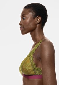 Grön spetsbh med intrikata mönster, som har ett brett vinrött band. Mjuk textur och triangel-form, med justerbara band.