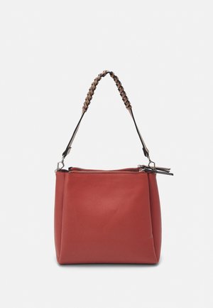 Bolso de mano de cuero rojo con asa trenzada en marrón y negro y cierre superior con cremallera, exhibido sobre un fondo blanco liso.