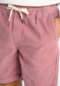 Bermuda in cotone a coste color rosa polveroso con vita regolabile tramite coulisse, dotate di tasche laterali e vestibilità rilassata.