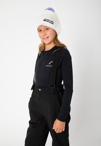 White knitted beanie with pink and blue pom-pom; black long-sleeve shirt with logo; black suspenders and black pants with pockets.