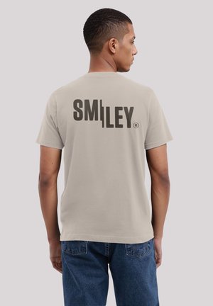 Helles graues Baumwoll-T-Shirt mit einem großen schwarzen "SMILEY"-Logo auf dem Rücken. Klassische Passform mit kurzen Ärmeln und rundem Halsausschnitt.
