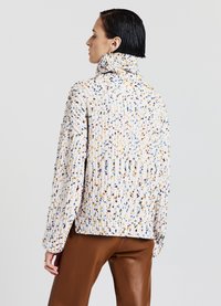 Maglione lavorato a maglia con collo alto, caratterizzato da un mélange di puntini multicolori su una base bianca, con un motivo a coste testurizzato e una vestibilità ampia.