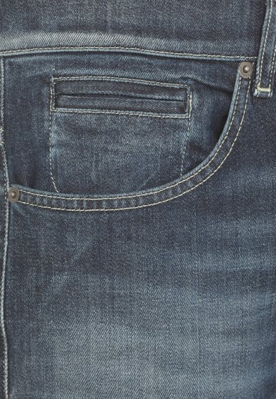 Jeans in denim blu scuro con una tasca posteriore, cuciture chiare e una finitura texture con un leggero effetto sbiadito.