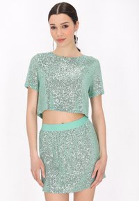 Set v mátové zelené barvě skládající se z crop topu a sukně, který se pyšní třpytivým designem z flitrů, krátkými rukávy a vysokým pasem se strukturovanými akcenty.