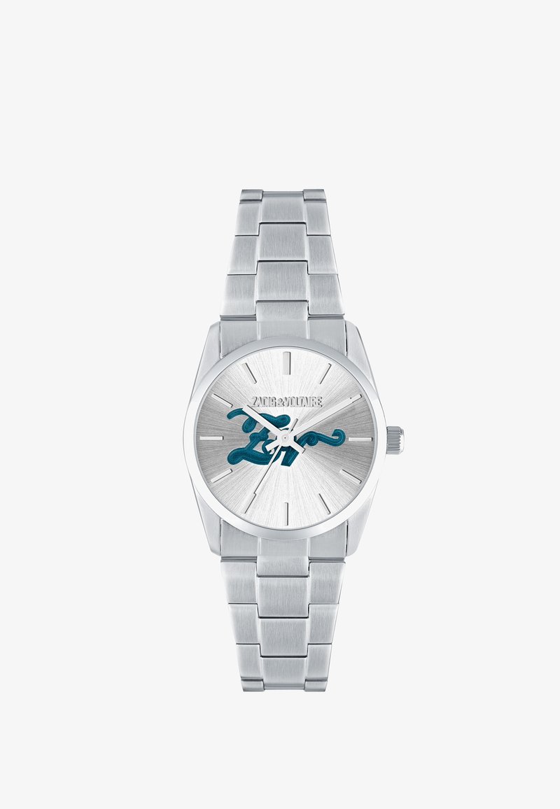 Stříbrné kovové náramkové hodinky s propleteným náramkem, minimalistickým ciferníkem a modrým stylizovaným logem „Zadig & Voltaire“ na ciferníku.
