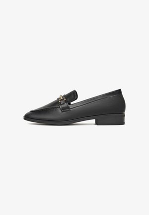 Loafers negre din piele, cu vârful ușor ascuțit, toc plat și un accent decorativ cu cataramă aurie pe vamp. Textură netedă și design minimal.