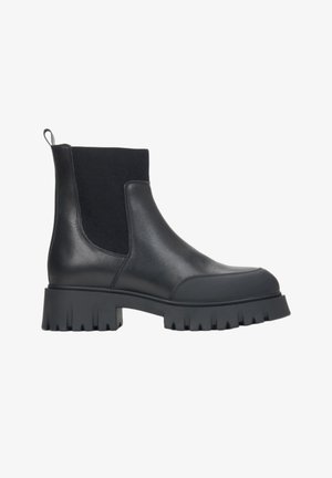 Czarne skórzane botki za kostkę z elastycznymi panelami bocznymi, masywną gumową podeszwą oraz uchwytem z tyłu ułatwiającym zakładanie. Teksturowane wykończenie.