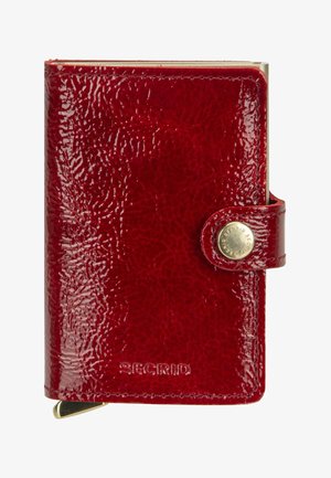 Kompakte glänzende rote Lederbrieftasche mit Druckknopfverschluss und geprägtem Markennamen „Secrid“ vorne.