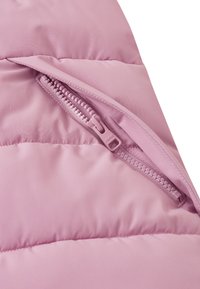 Gilet imbottito rosa con un esterno liscio e lucido e una tasca laterale con zip. Il tessuto è morbido e trapuntato, con una sensazione di leggerezza.