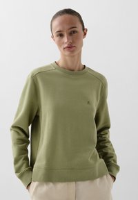 Olivengrønt sweatshirt med ribbet tekstur, rund udskæring og lange ærmer; har et subtilt logo på brystet og en afslappet pasform.