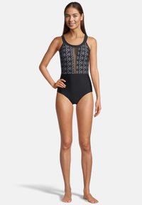 Maillot de bain une pièce noir avec un panneau en maille à motif au niveau de la poitrine. Présente un ajustement serré, des bretelles larges et un design à jambe haute.