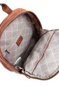Sac à dos en cuir marron ouvert montrant une doublure en tissu gris clair à motifs, une poche intérieure zippée et une petite étiquette blanche à l’intérieur.