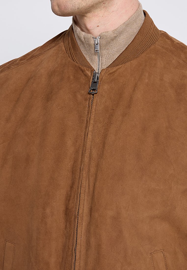 Brązowa skórzana kurtka bomberka z żebrowanym kołnierzem, zamkiem błyskawicznym z przodu i kieszeniami bocznymi, charakteryzująca się gładką fakturą i nowoczesnym wzornictwem.