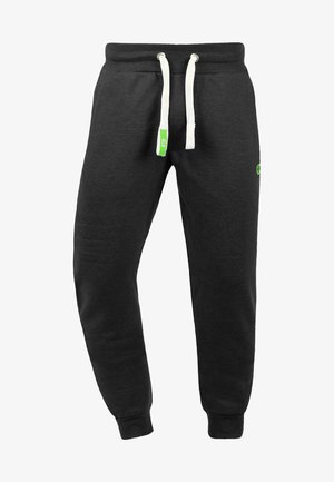 Sorte joggebukser i mykt stoff med tapered fit. Har snor i livet, hvite detaljer, sidelommer, og en grønn logo.