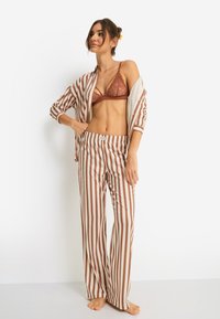 Σετ πυτζάμες με ρίγες σε καφέ και κρεμ αποχρώσεις, περιλαμβάνει πουκάμισο με κουμπιά και άνετη εφαρμογή και παντελόνι με ελαστική μέση, κατασκευασμένο από απαλή, ελαφριά ύφανση.