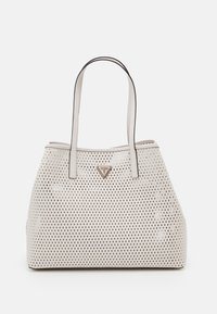 Sac fourre-tout en cuir blanc perforé avec deux anses, accent de logo triangulaire et forme rectangulaire. Surface texturée avec découpes en forme de losange.