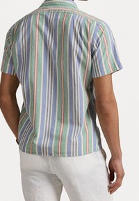 Košile s krátkým rukávem v světle modré, zelené a červené vertikální pruhy. Vyrobeno z bavlny s měkkou texturou. Obsahuje klasický límec.