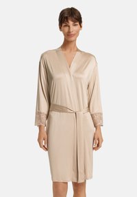 Accappatoio in satin beige con maniche 3/4 e dettagli in pizzo sui polsini, presenta un design avvolgente e una cintura coordinata, texture liscia.