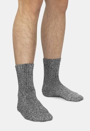 Gray knitted socks, showing a textured fabric with a ribbed cuff. They cover the ankle and have a reinforced toe.