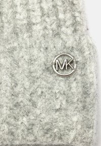 Cappello di lana grigio lavorato a maglia con un motivo strutturato e un logo circolare argento con le lettere "MK" al centro.