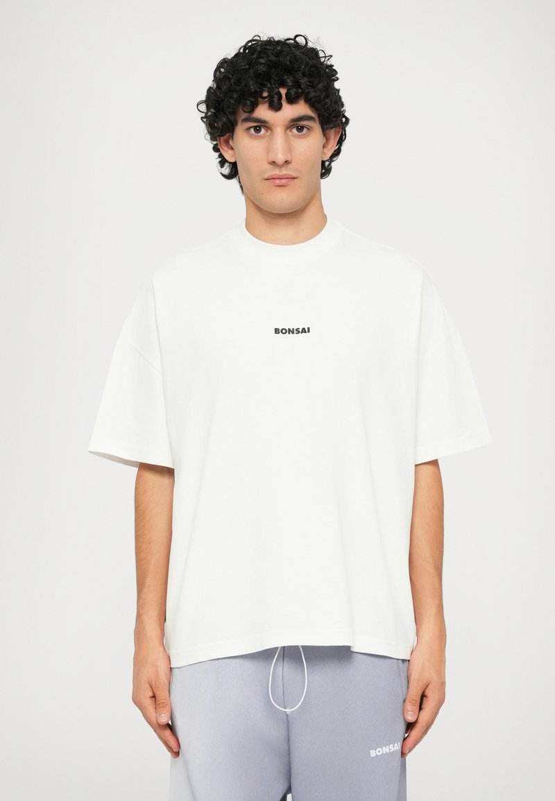 White cotton t-shirt with a crew neckline and short sleeves. Features a small black "BONSAI" text logo on the chest. Smooth texture.