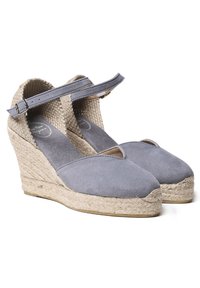 Šedé semišové wedge espadrilky s pletenou juteovou podrážkou. Obsahují pásek kolem kotníku a design s odkrytými prsty. Texturovaný vnitřek.
