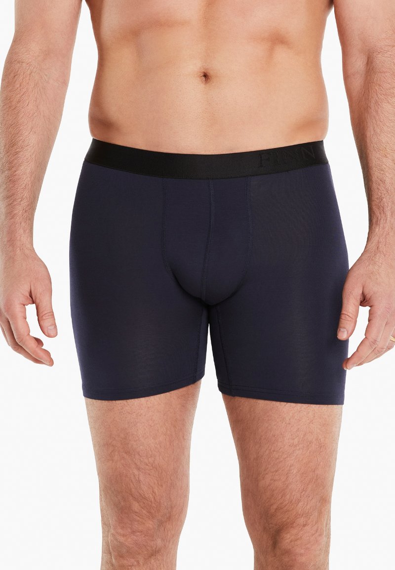 Marineblaue Boxershorts aus glattem Material mit einem schwarzen Gummibund, der mit Markenaufschrift versehen ist. Enganliegendes Design mit kurzem Bein.