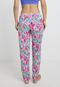 Kleurige broek met bloemenprint in een mix van roze, rood, groen en blauwe tinten; losse pasvorm met elastische tailleband en taps toelopende boorden.