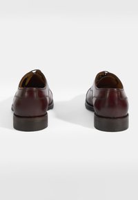 Chaussures en cuir bourgogne avec une finition lisse, bout arrondi et semelle en caoutchouc marron. Présente un minimum de coutures et aucun matériel visible.