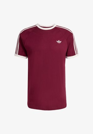 Burgundski kratki rukav majica s bijelim detaljima, klasičnim okruglim izrezom i tri bijele pruge na svakom ramenu. Na prsima je mali logotip.