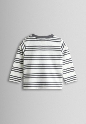 Pikaste varrukatega valge puuvillane särk hallide horisontaalsete triipudega. Omaduseks hall ümar kaelus ja kergelt lõdvalt istuv lõige.