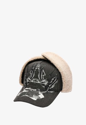 Casquette en denim noire avec des cache-oreilles en polaire beige, ornée d'un motif graphique d'aigles et de l'année "1971" affichée en évidence à l'avant.