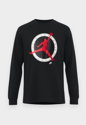 Cămașă neagră cu mâneci lungi, având un logo mare Air Jordan roșu și alb, cu o siluetă a unui jucător care face un dunk în centru.