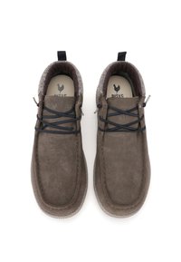 Een paar casual schoenen van bruin suede met zwarte veters en een zachte, gepolsterde binnenvoering, gezien van bovenaf op een witte achtergrond.