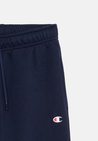 Námořnické tepláky so strečovým pásom v páse s nášivkou loga. Mäkkučký materiál, voľný strih a detaily so šnúrkou pri páse.