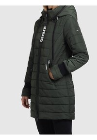 Zielona pikowana parka z kapturem, z pełnym zapięciem na zamek, ściągaczem i kontrastowymi czarnymi ściągaczami na mankietach. Detal z logotypem z przodu.