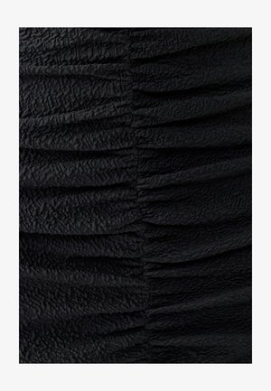 Tessuto nero arricciato con una superficie testurizzata. Presenta evidenti pieghe orizzontali che creano un motivo ondulato. Aspetto morbido e drappeggiato.