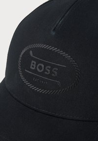 Fekete, texturált felületű anyagból készült sapka; kiemelkedő fekete "BOSS" logóval és a megalapítás dátumával, klasszikus dizájnban hímezve.