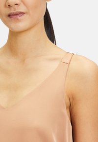 Lichtroze satijnen camisole met een V-hals, smalle straps en een gladde textuur. Geen zichtbare patronen of hardwaredetails.
