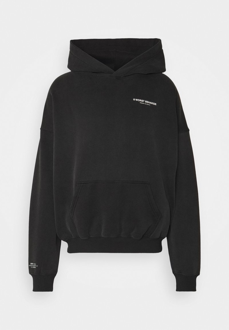 Sweat à capuche noir avec poche frontale, poignets et ourlet côtelés, petit texte blanc "WORST BEHAVIOR" sur la poitrine et détails des manches.