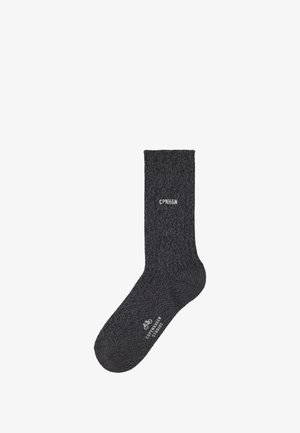 Gray knitted sock with a textured pattern, featuring logo “CPNHGN” in white. Ankle length design with ribbed cuff for fit and comfort.