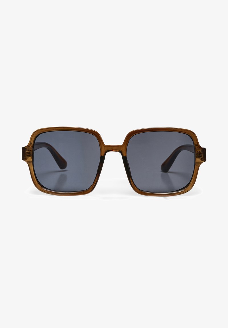 Occhiali da sole di forma quadrata con lenti scure e montatura traslucida color ambra marrone, mostrati frontalmente su uno sfondo bianco.