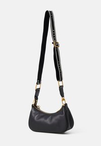Bolso de hombro de cuero negro con forma curva, herrajes dorados y una correa ajustable con un diseño de logo a rayas.