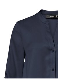 Blusa azul marino oscura con un collar redondeado, cierre de botones y mangas largas. Fabricada con una tela suave y ligera con un diseño minimalista.