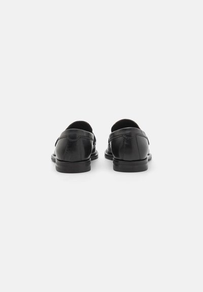 Schwarze Lederschuhe mit glatter Oberfläche und abgerundeter Zehe. Mit niedrigem Absatz und dezenten Nähten auf der Rückseite.